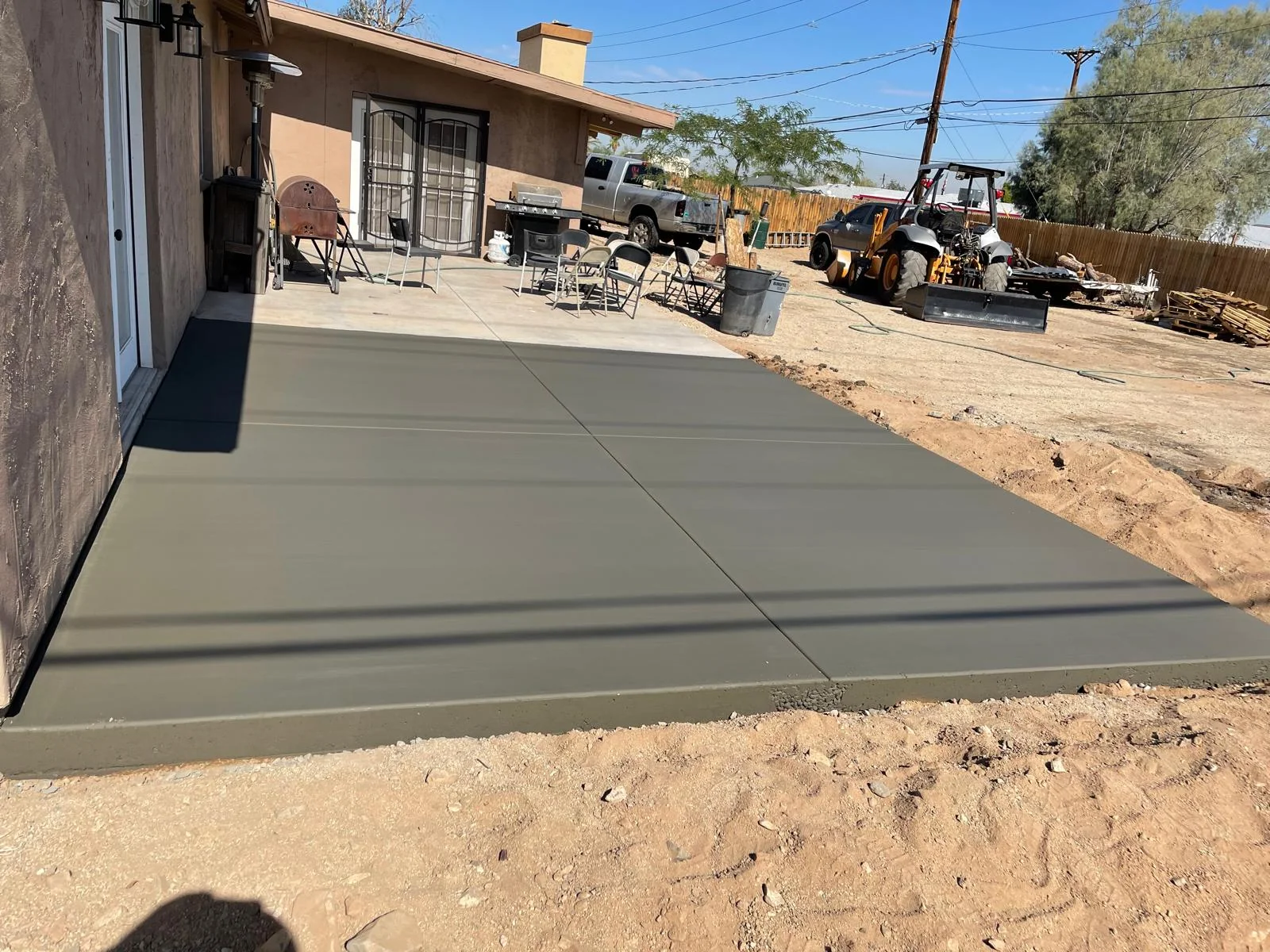 Newly placed rectangular backyard concrete slab with crisp control joints