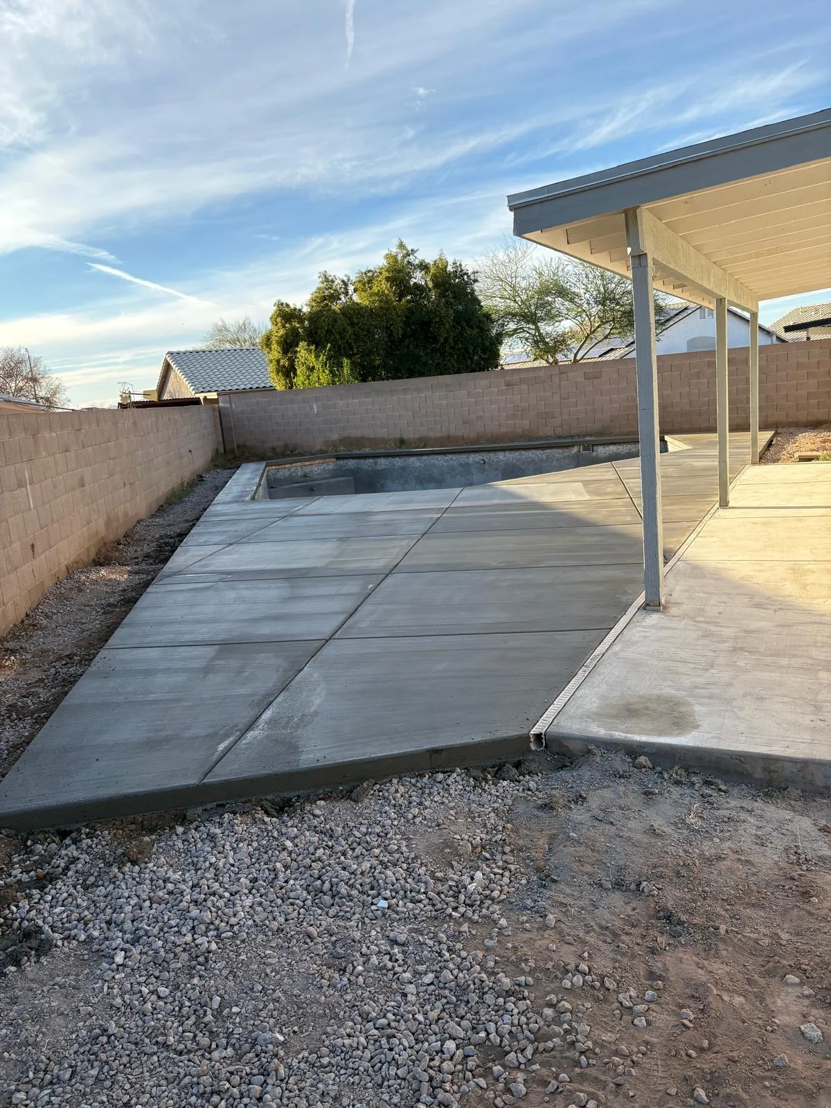Finished rectangular concrete utility pad beside a Phoenix-area residence